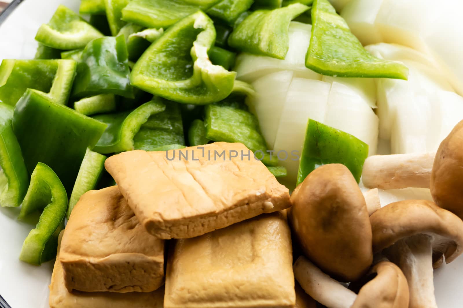 Green peppers, tofu, onion, and mushrooms in plate