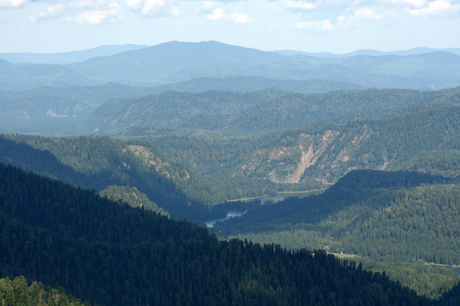 View from the top, on the valley between the mountains with the current river. Altai, Siberia, Russia.