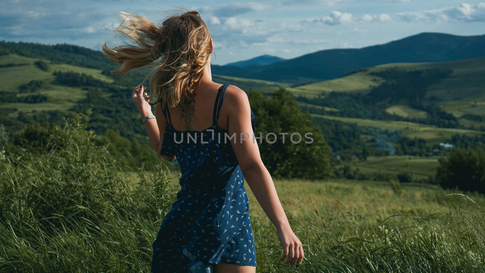 Woman in mountains at sunny day time. Beautiful natural mountain background. Ukraine, Carpathian mountains. Natural colors