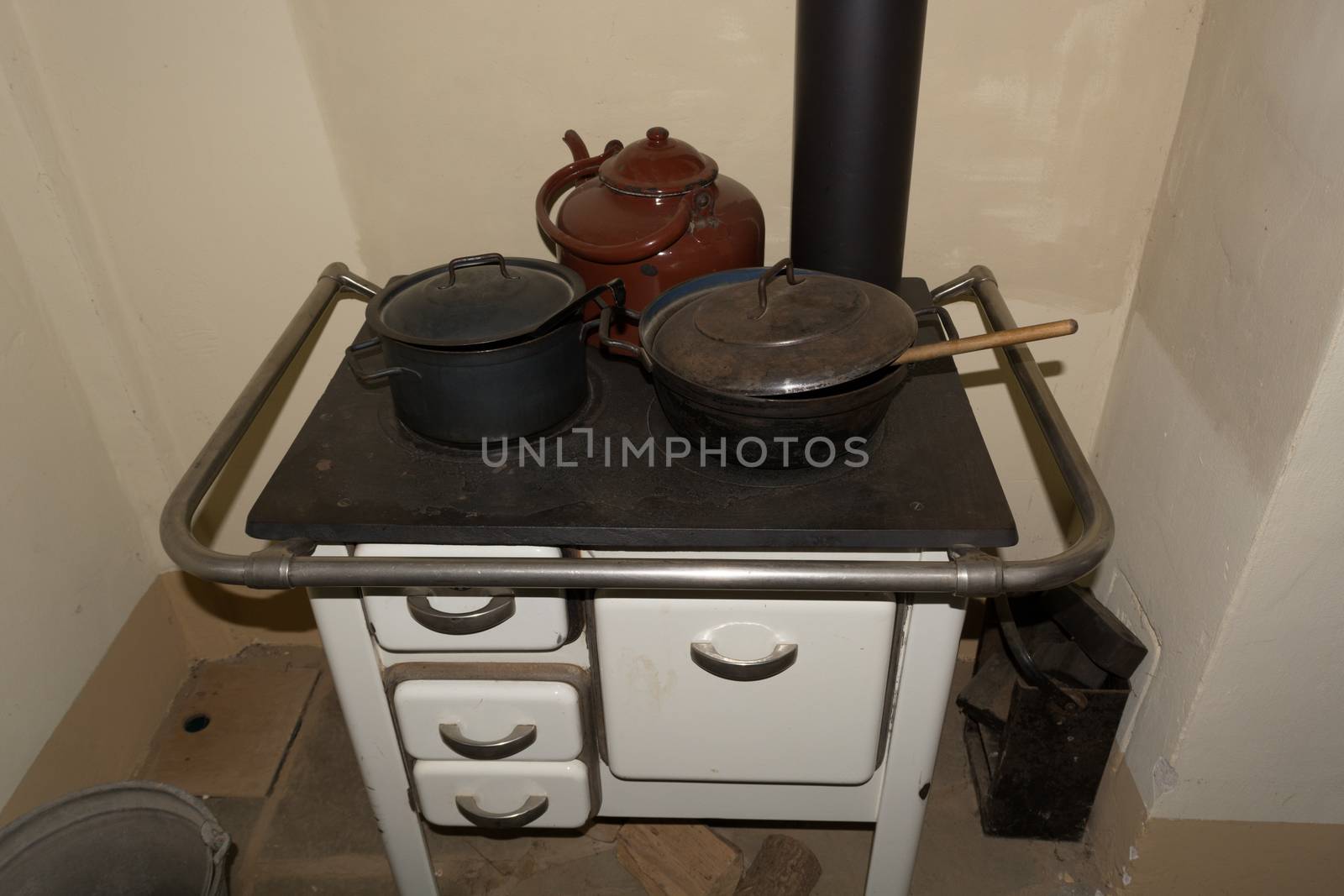 Old-fashioned kitchen stove, oven with kettles in a rustic kitchen chalet.