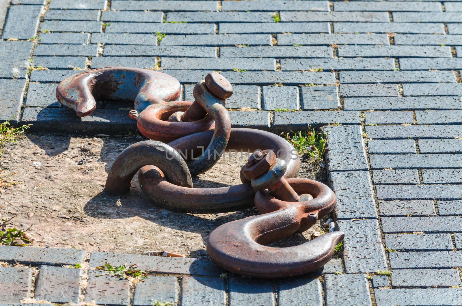 Old and rusty mooring ring for ships fixing. Dock for small boats.