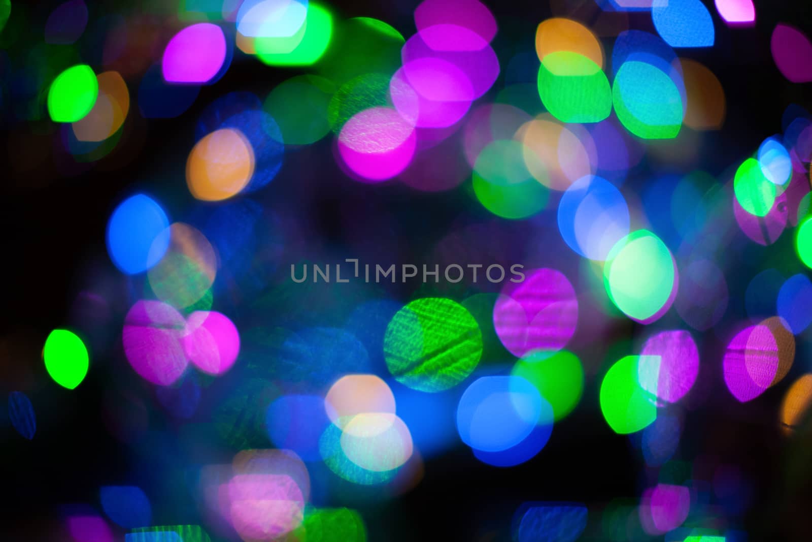 Abstract blurred background with numerous colourful bright festive bokeh. Texture with copy space for text. Celebration, holidays concept. Horizontal.