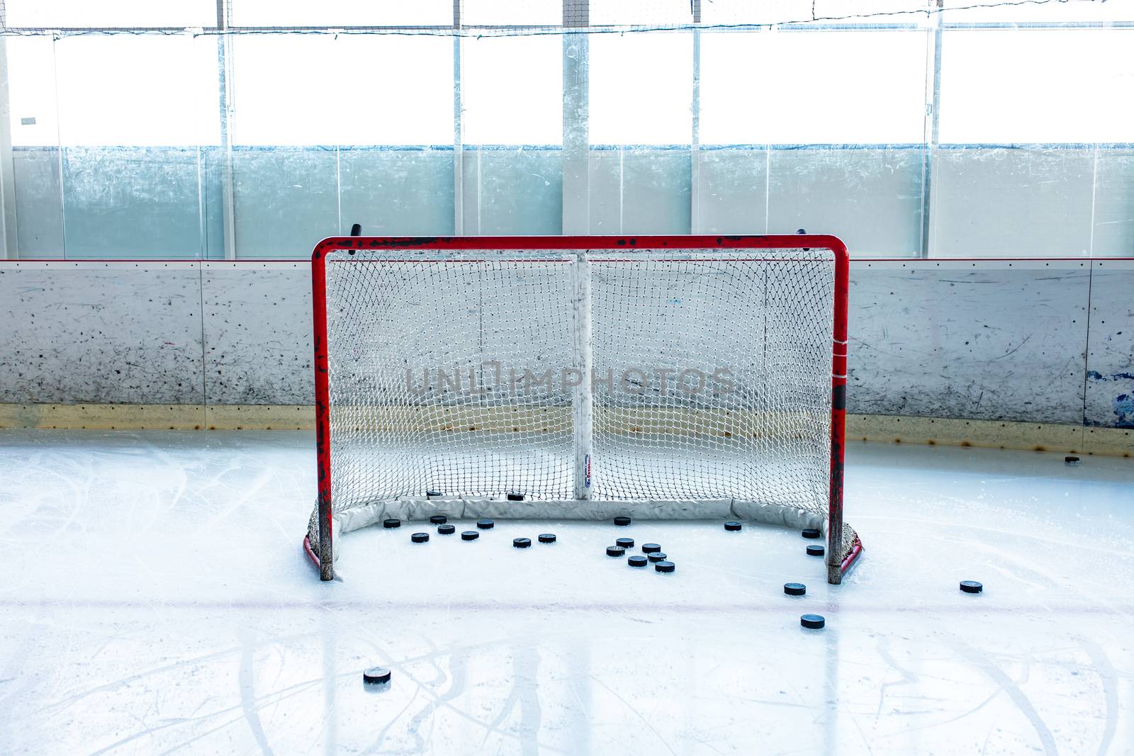 ice hockey ice rink, pucks and empty red net