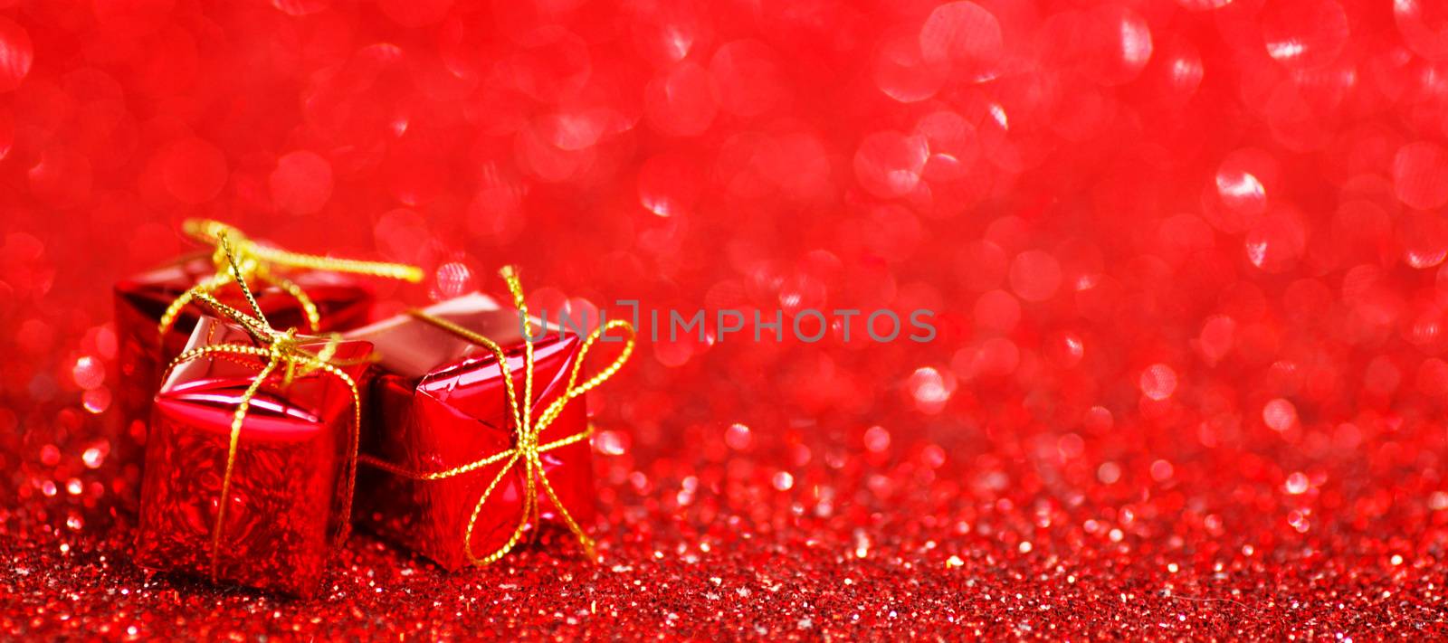 Small decorative gift boxes on shiny glitter background