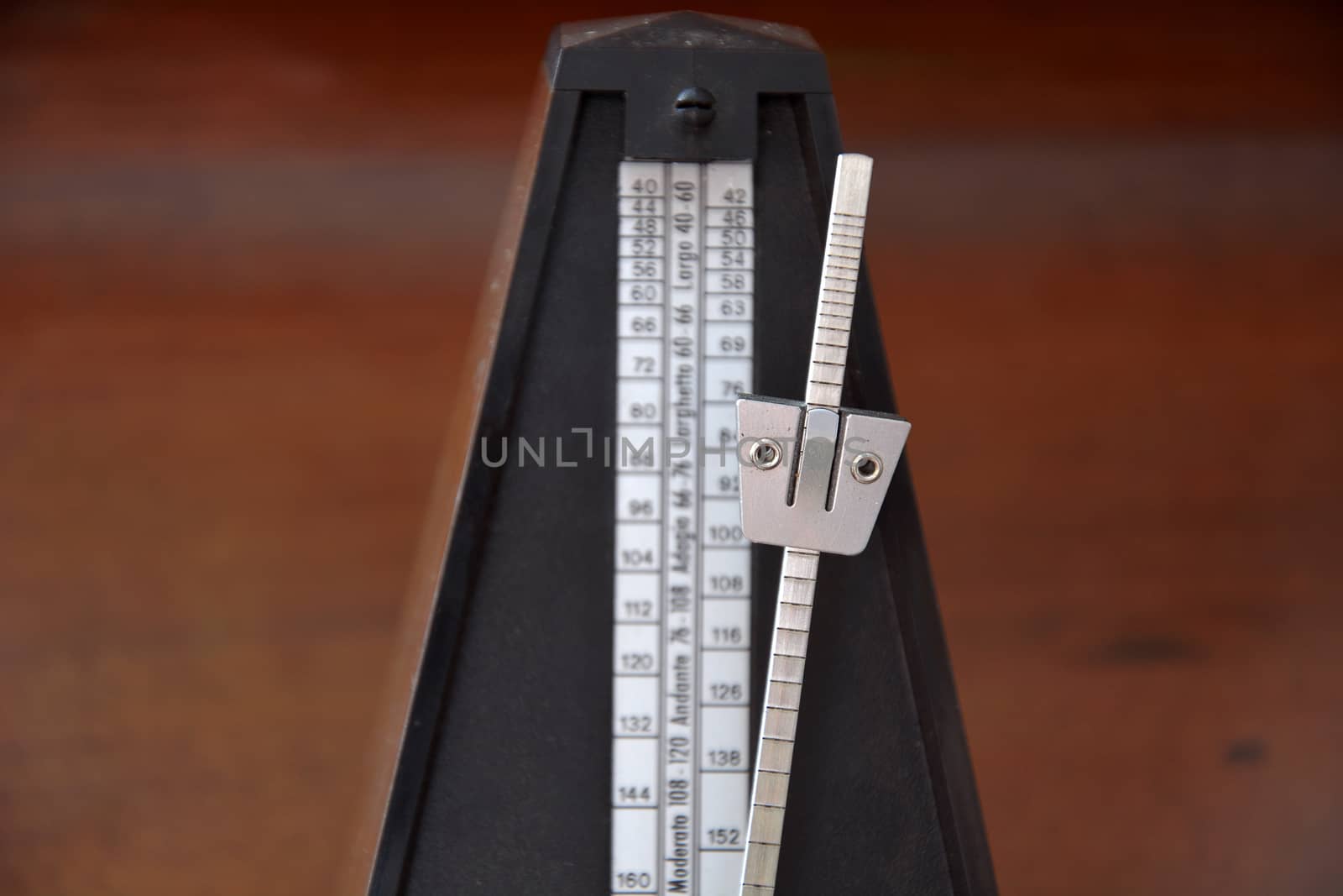 Close up of a vintage metronome with swinging pendulum