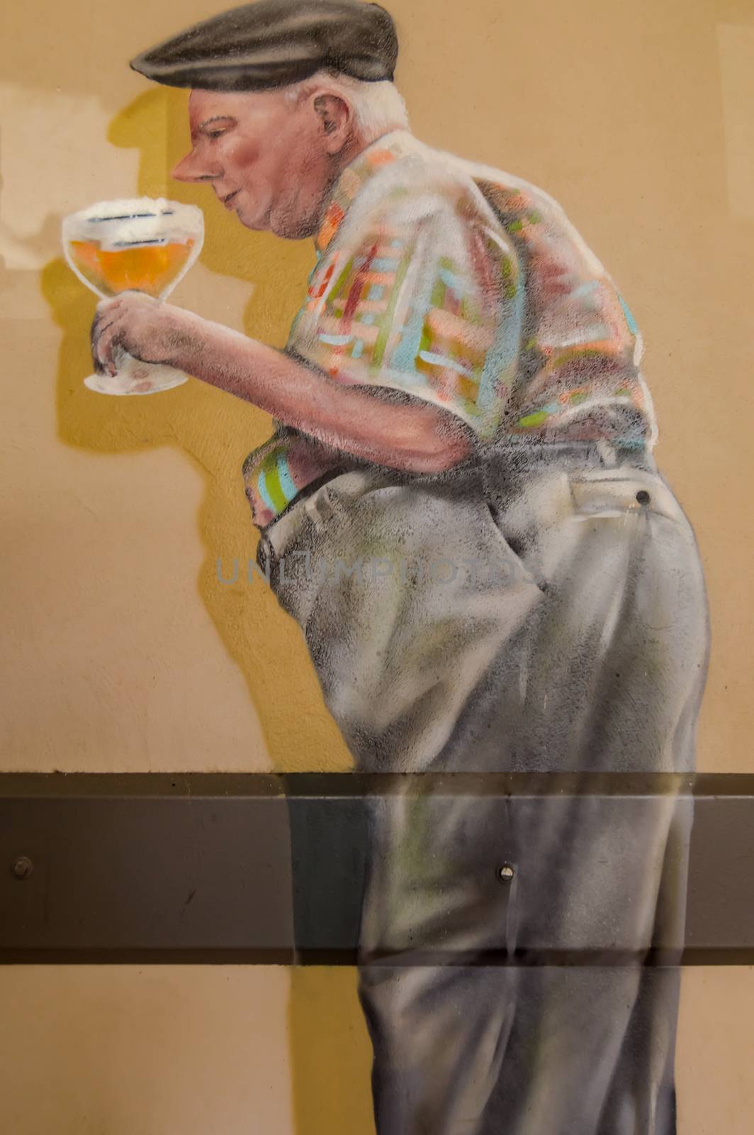 Caricature of a paunchy figure holding a glass of orval in his hand on a wall of a cafe in Gerouville