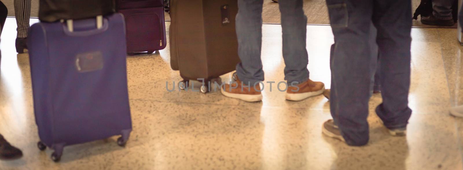 Panorama rear view long queue of passengers waiting with carry on luggage before on boarding to airplane at Seattle, Washington airport. Diverse group of multicultural travelers standing