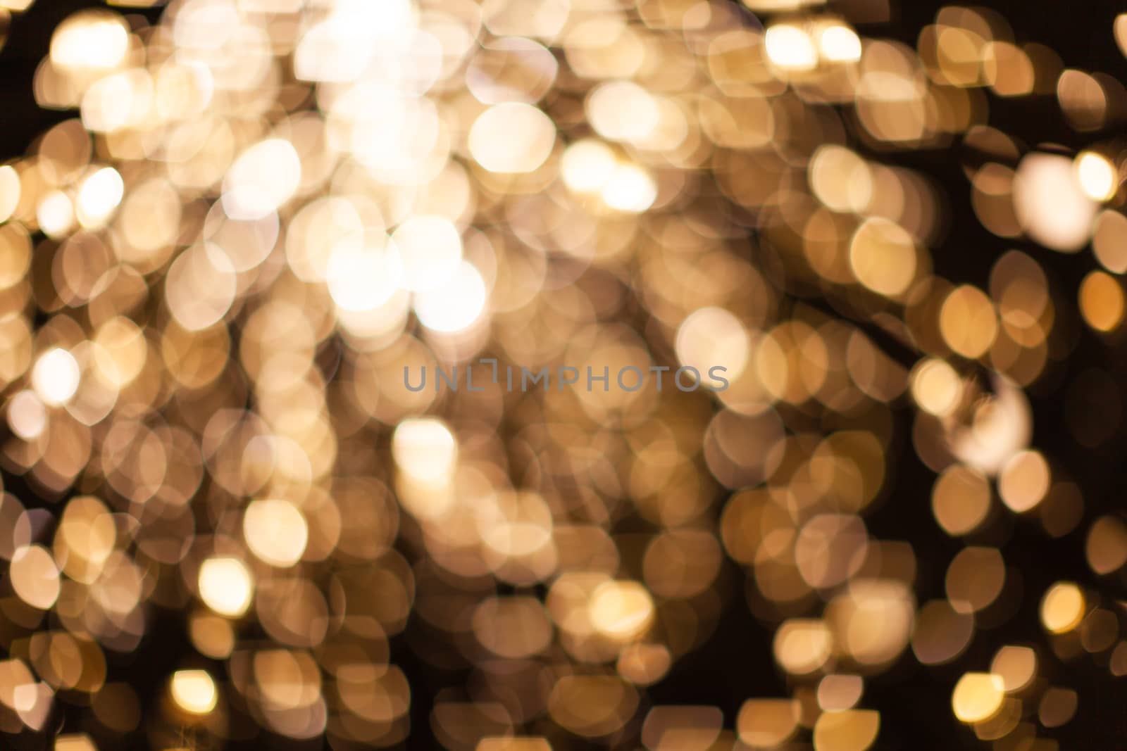 Abstract blurred background with numerous bright gold festive bokeh. Texture with copy space for text. Celebration, holidays concept. Horizontal.