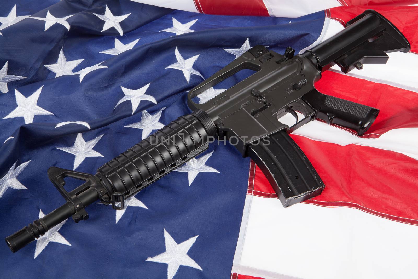 Submachinegun and American flag on a studio background