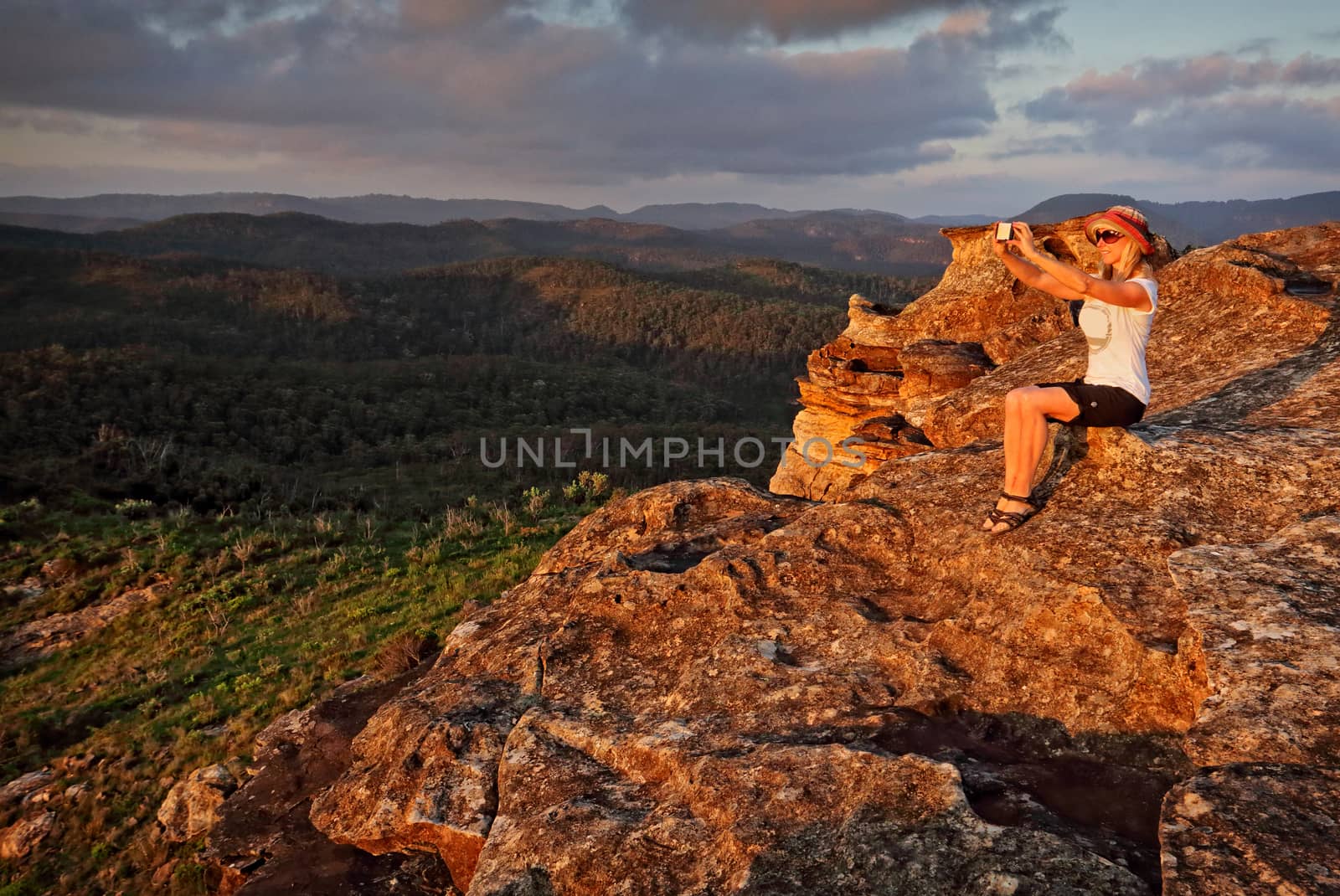 The selfie generation.  Woman taking a selfie with mobile phone in a rugged mountain landscape
