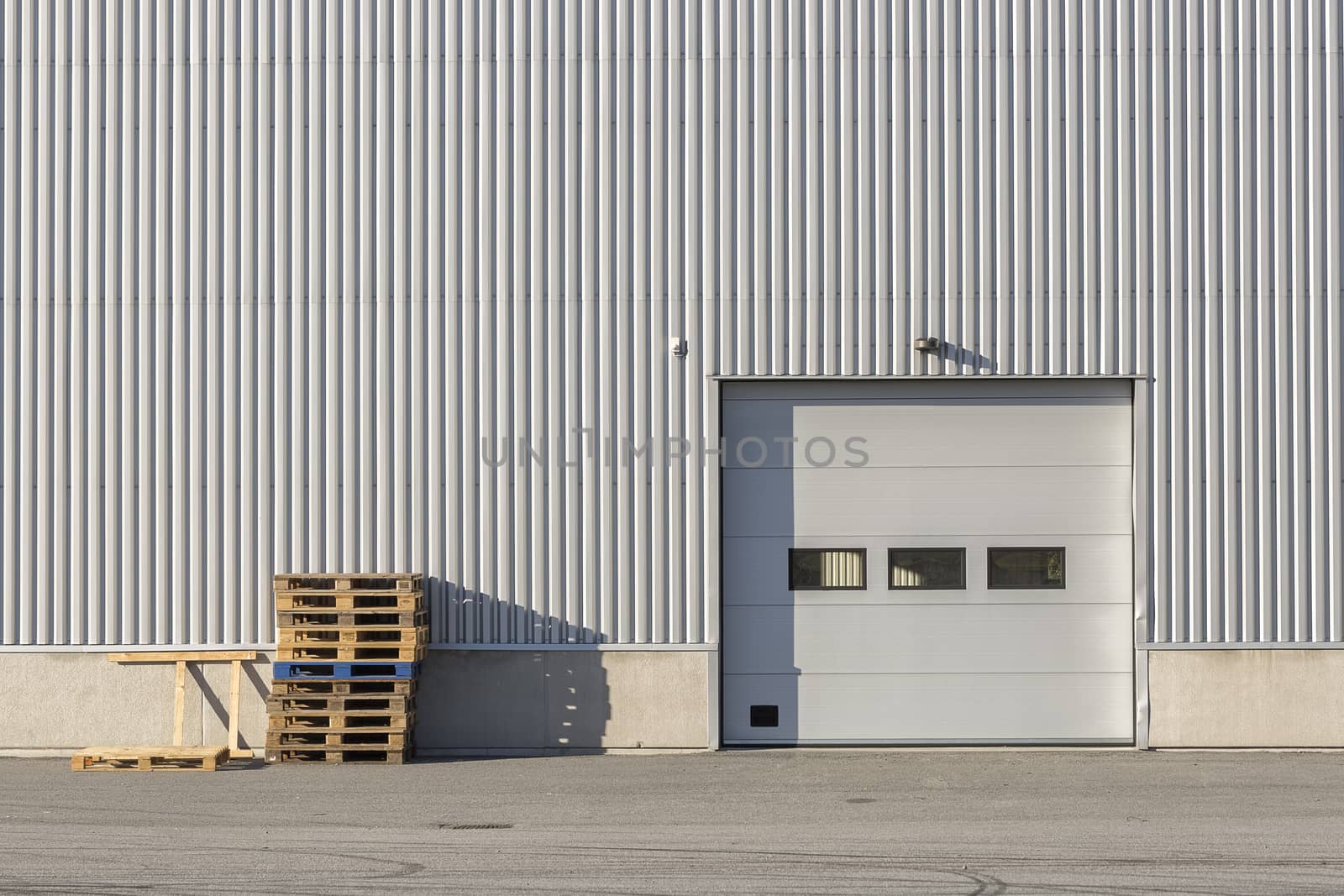 Industrial Building with Garage Door and Box Pallets.