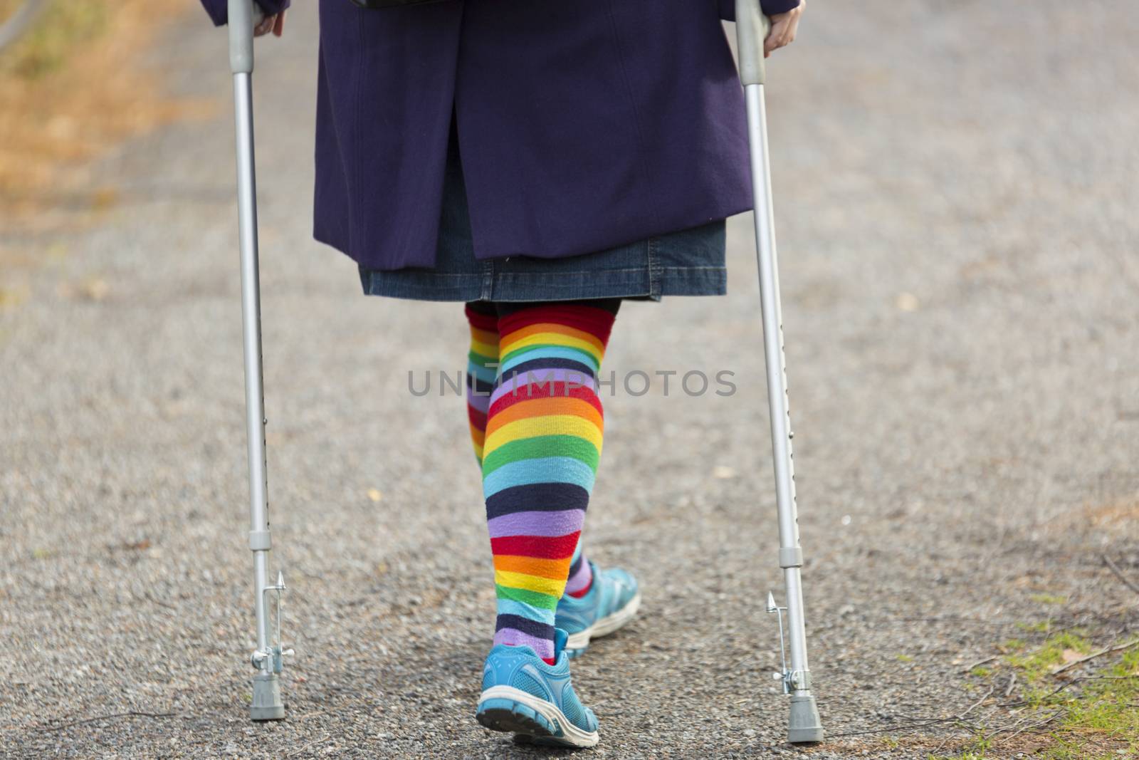 Female with Rainbow Leggings and crutches Walking.