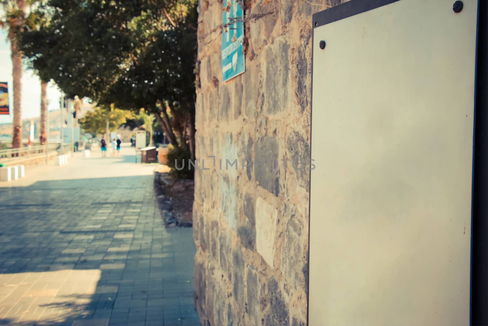 A blank sign on ancient brick wall at the Tiberias promenade.