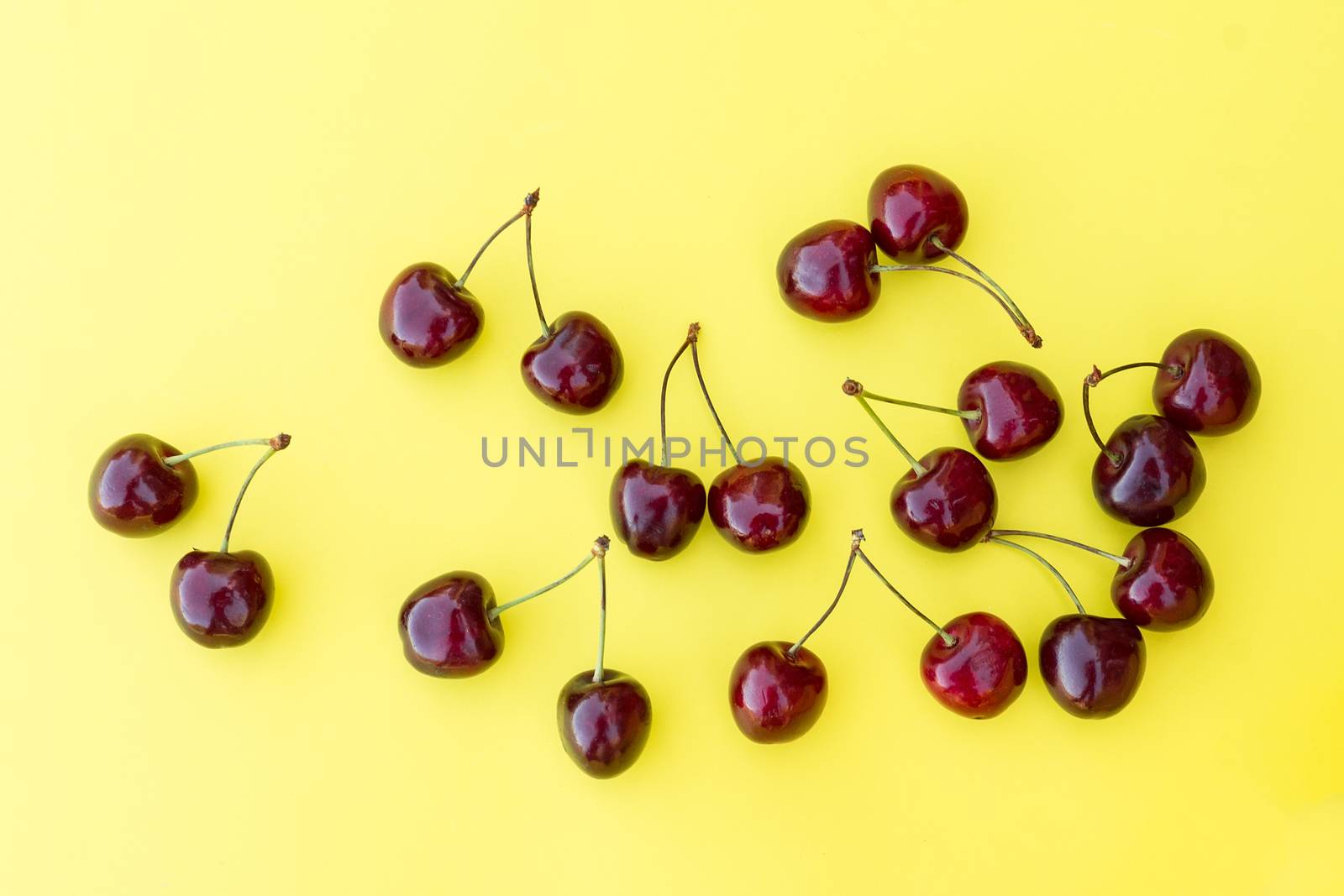 ripe fresh cherry on a yellow background