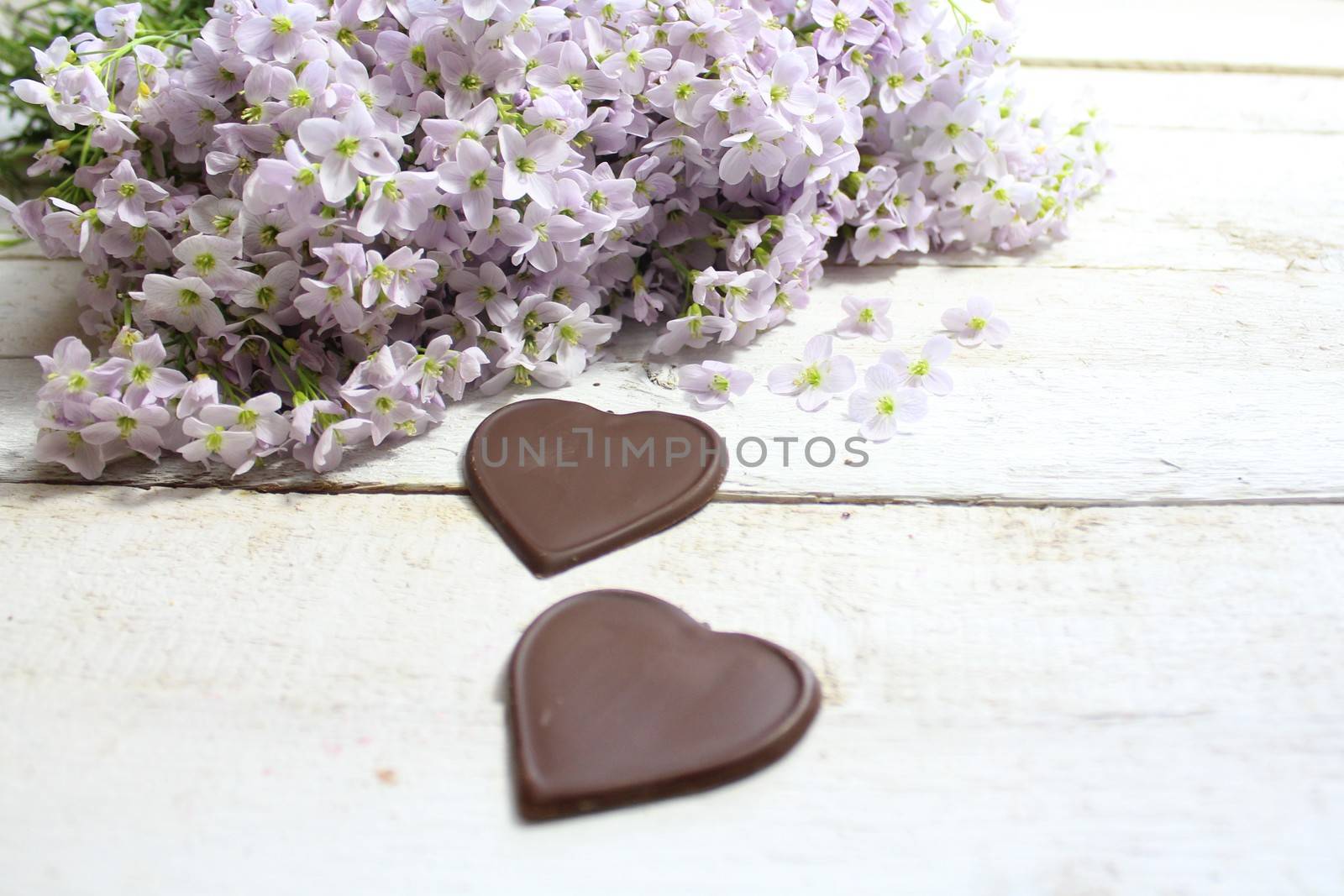 The picture shows cuckoo flowers with chocolate hearts.