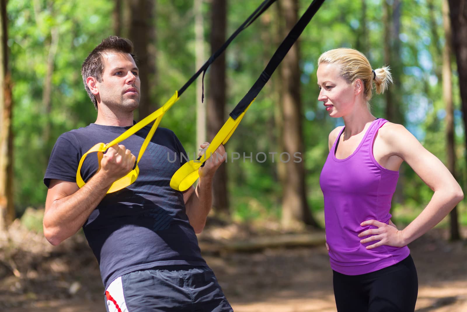 Young active people training with fitness straps outdoors. by kasto