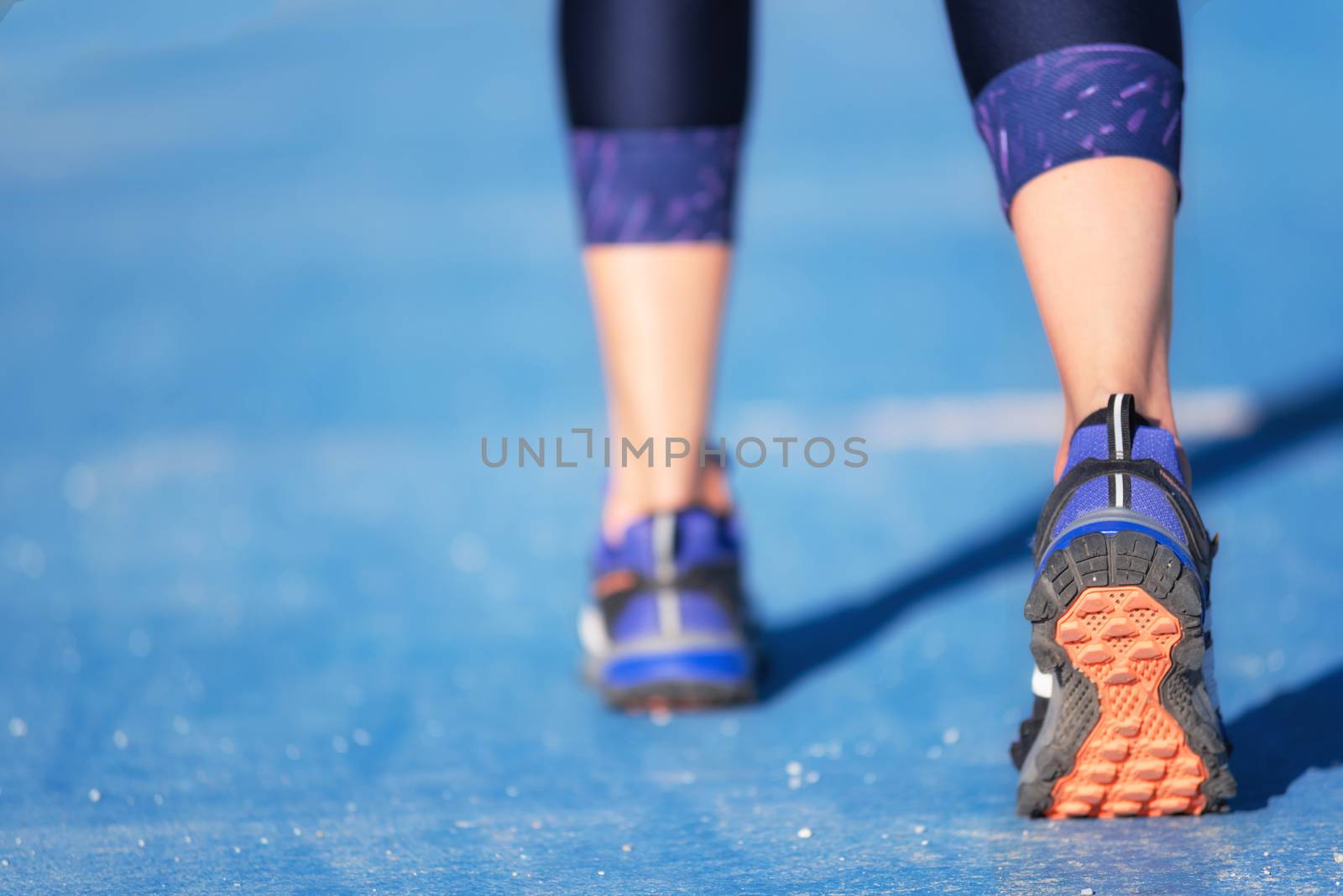 Runner feet running closeup on shoe. woman fitness jog workout w by HERRAEZ