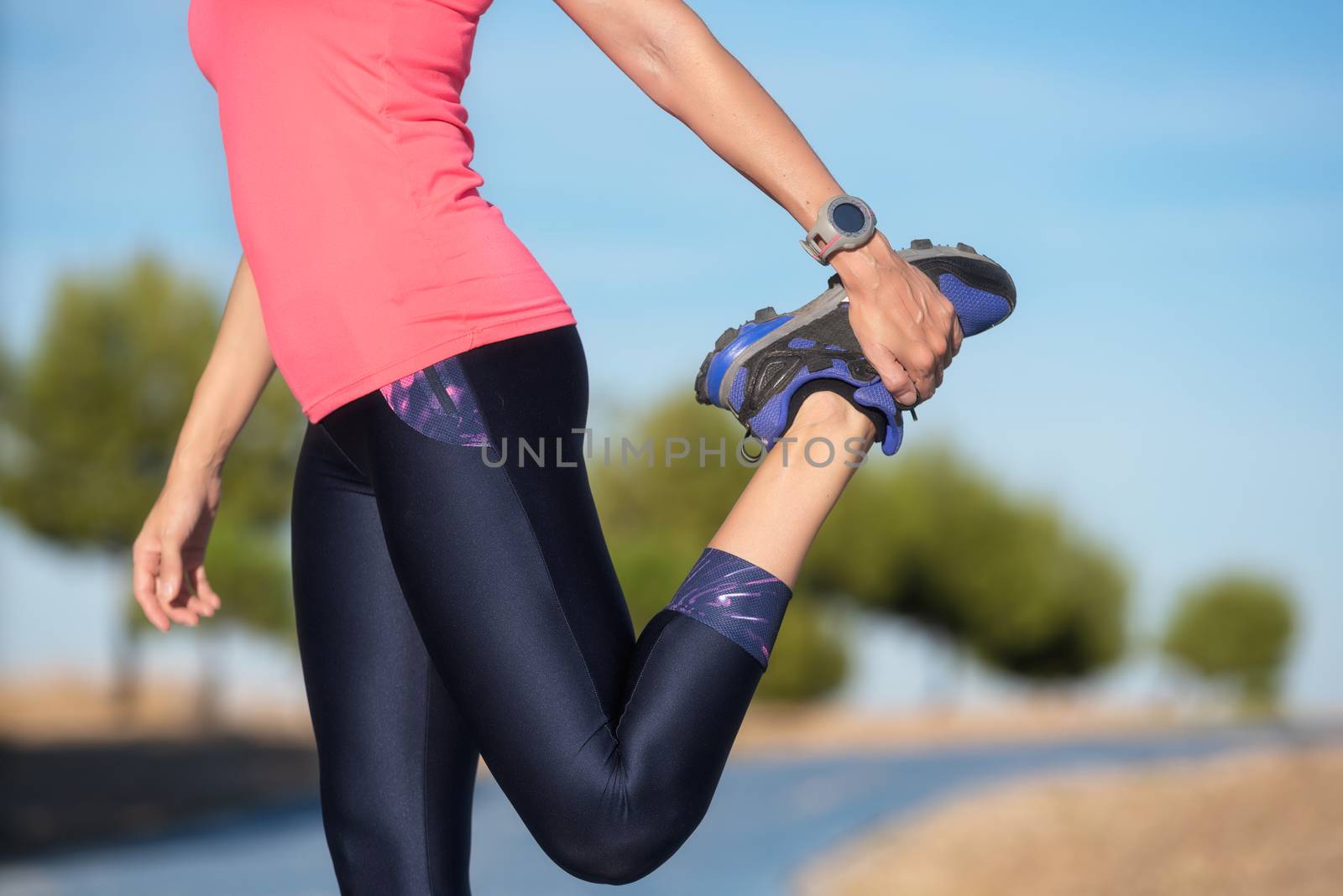 woman doing stretching exercise for legs, sport background. by HERRAEZ