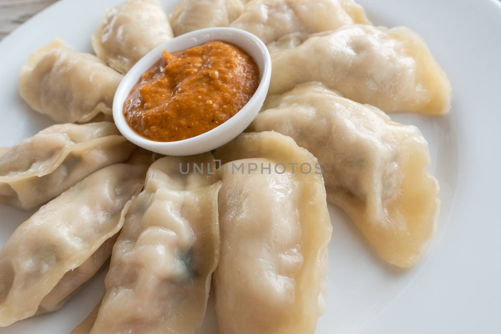 Plate of Nepalese chicken momos and its achar (sauce)