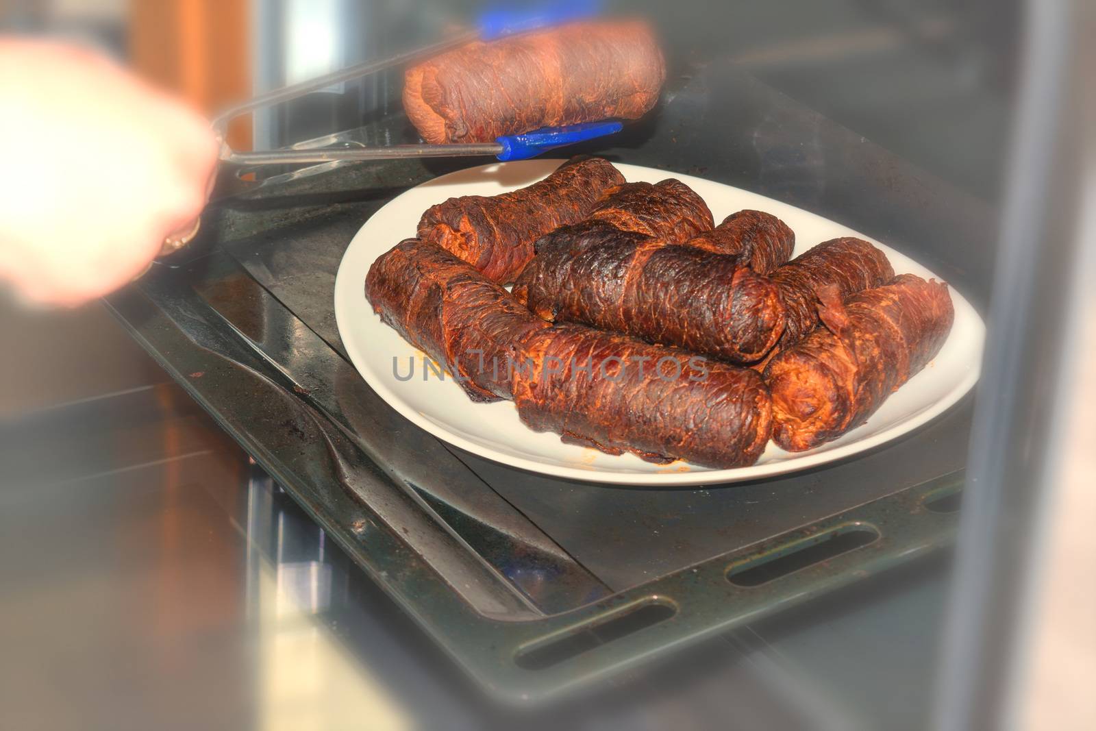 Fresh beef roulades braised in a dish in the oven.