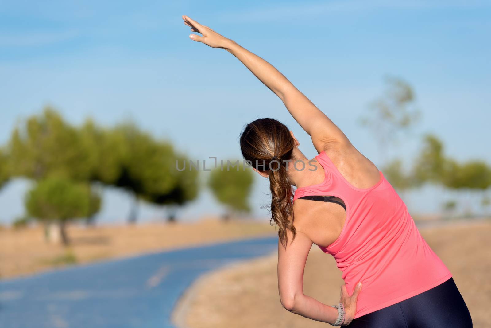 woman doing stretching exercise for back, sport background.