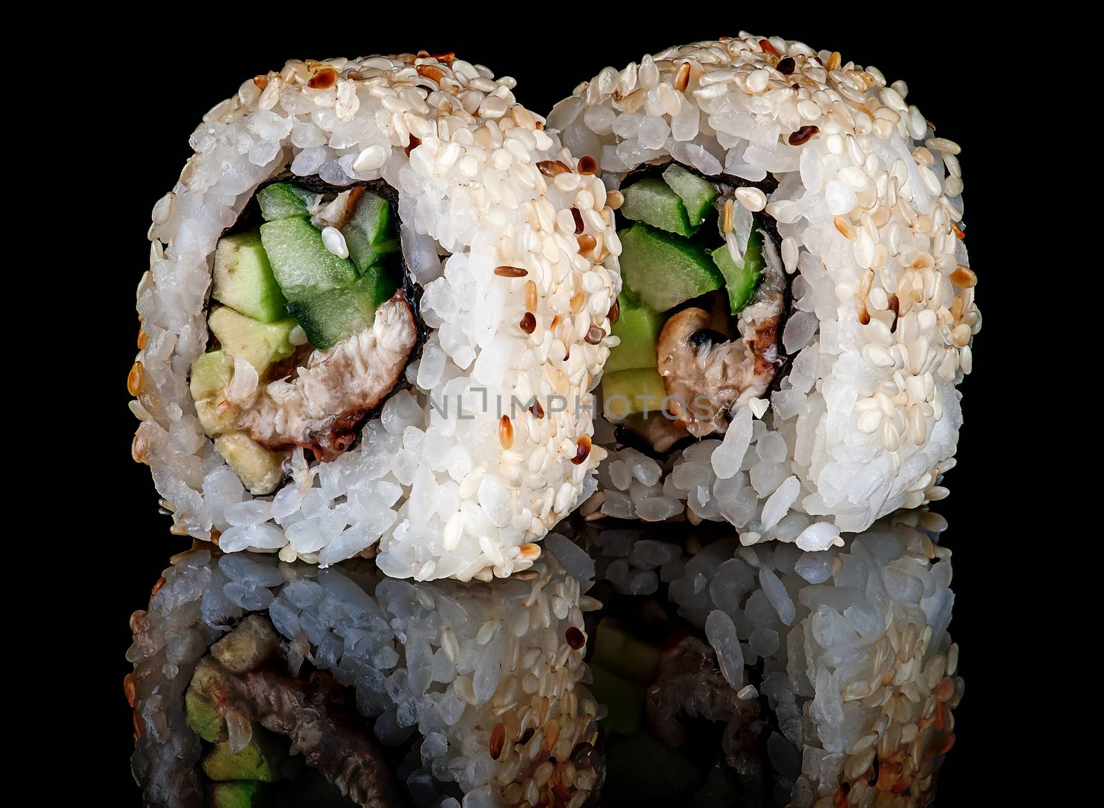 Closeup two sushi roll california on black background. Sushi roll with eel, vegetables and unagi sauce. Reflection.