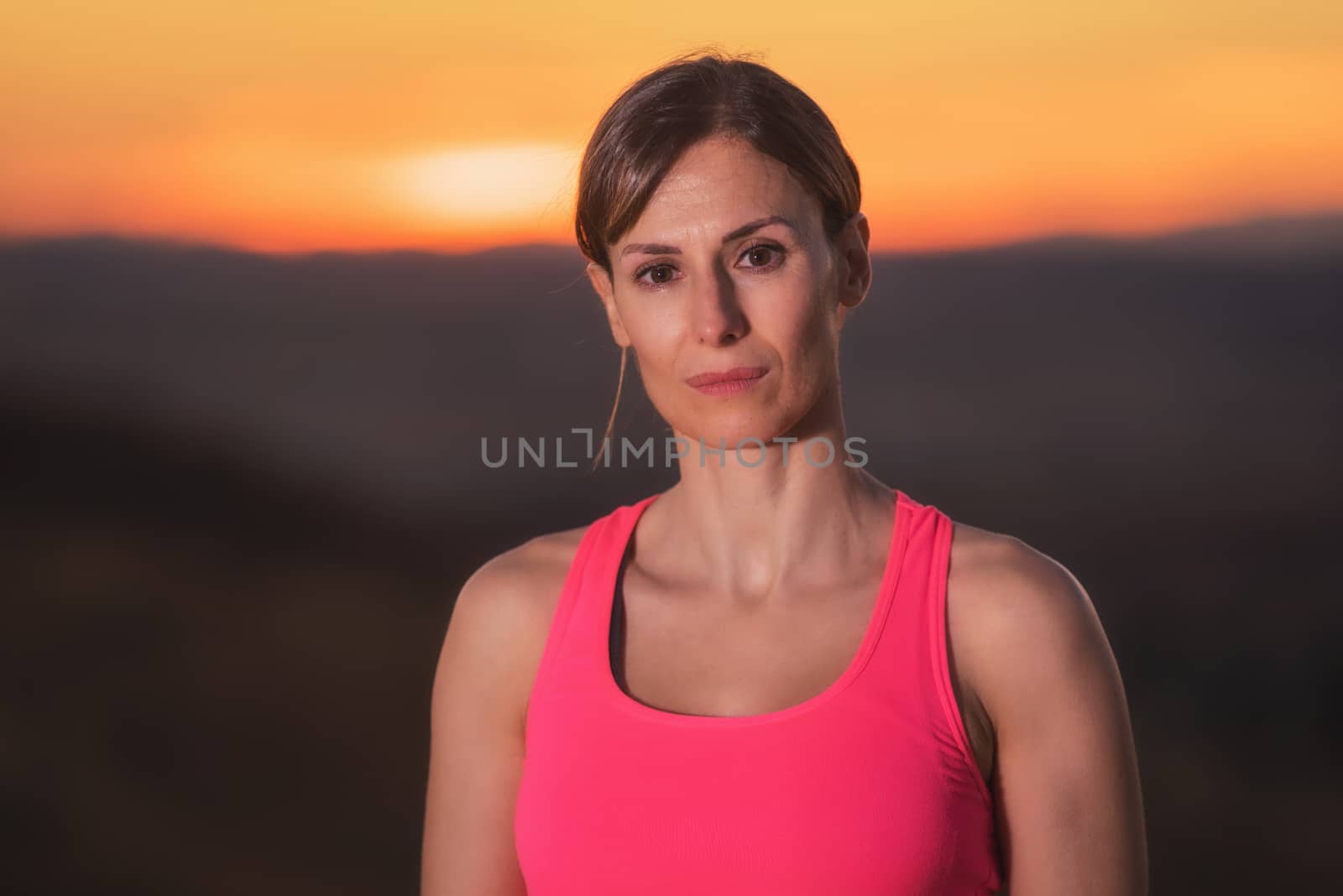 Young beautiful woman portrait in sport clothes at sunset by HERRAEZ