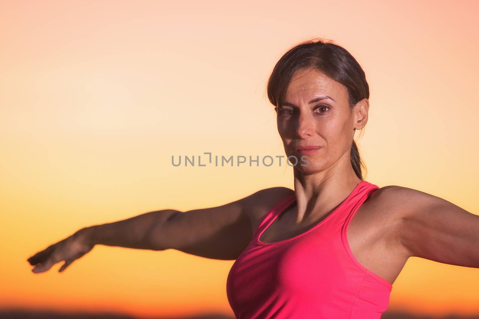 Young beautiful woman practicing Yoga at sunset by HERRAEZ