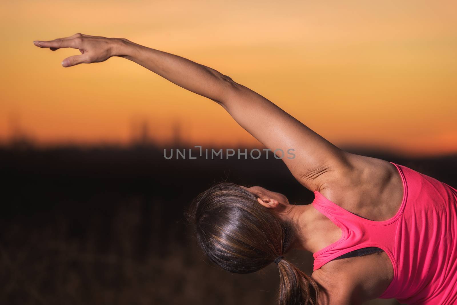 Young beautiful woman practicing Yoga at sunset by HERRAEZ