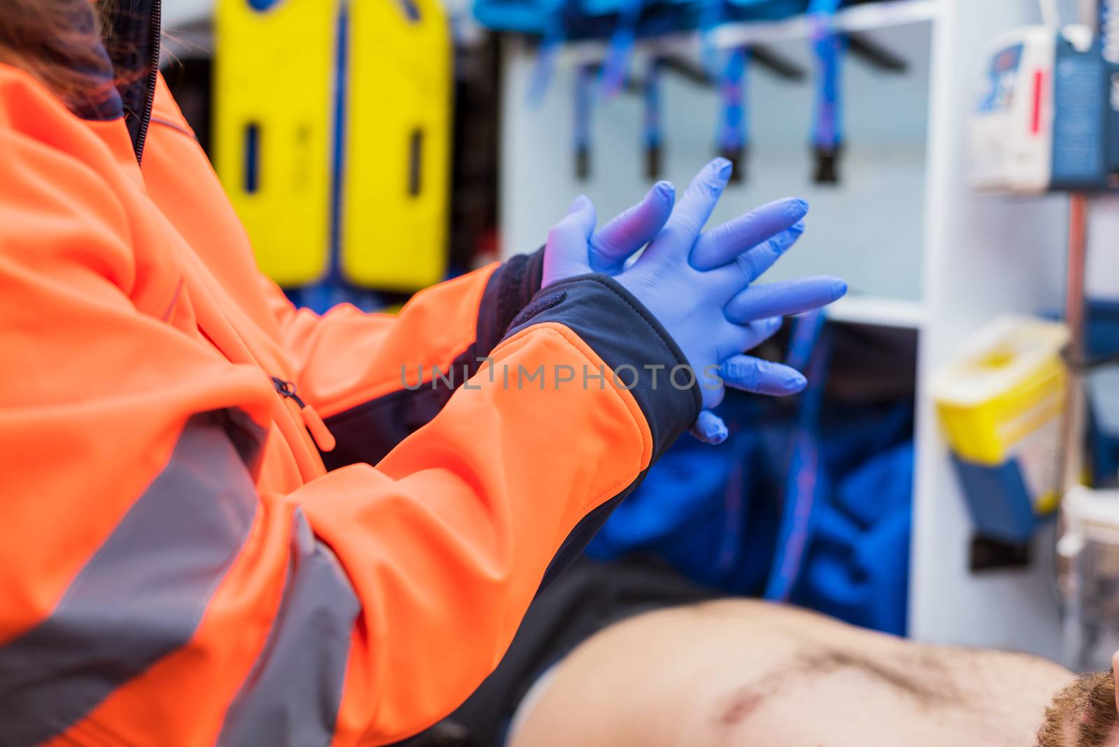 Emergency doctor putting on gloves in ambulance