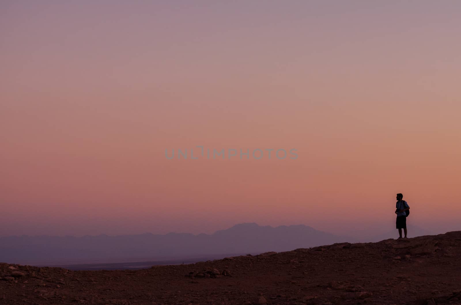 Man looks to a beautiful sunset in Atacama desert, Chile