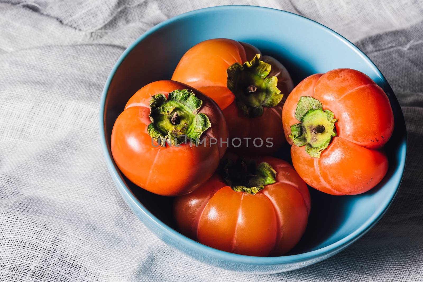 Bowl with Persimmons on White Textile by Seva_blsv