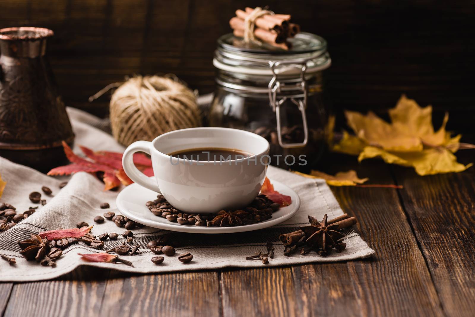 Autumn Leaves with Cup of Coffee. Ingredients, Spices and Some Kitchenware on dark wooden surface.