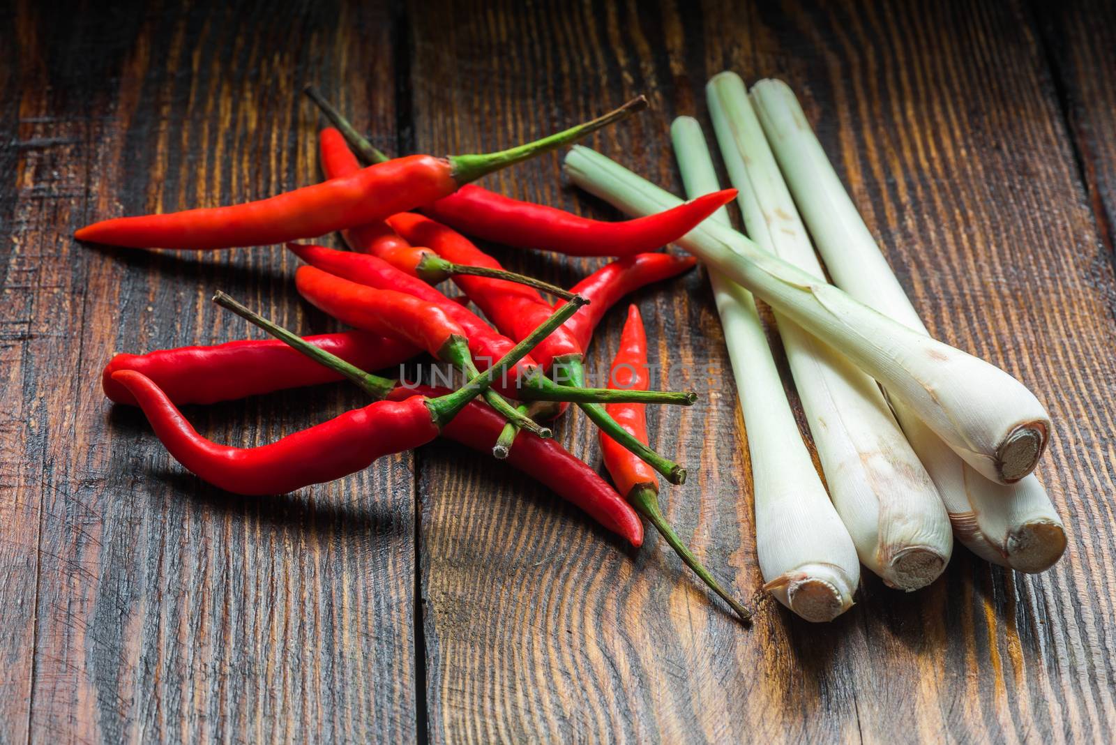 Pile of thai Bird's Eye Chilis with lemongrass on a old wooden background. Ingredients of asian cuisine.