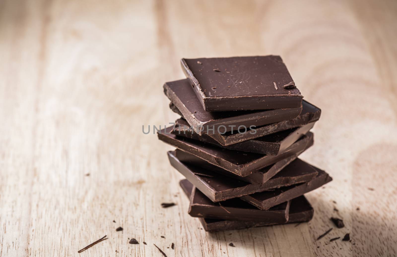 Dark Chocolate Bars Stack on Wooden Table. Place for Text.