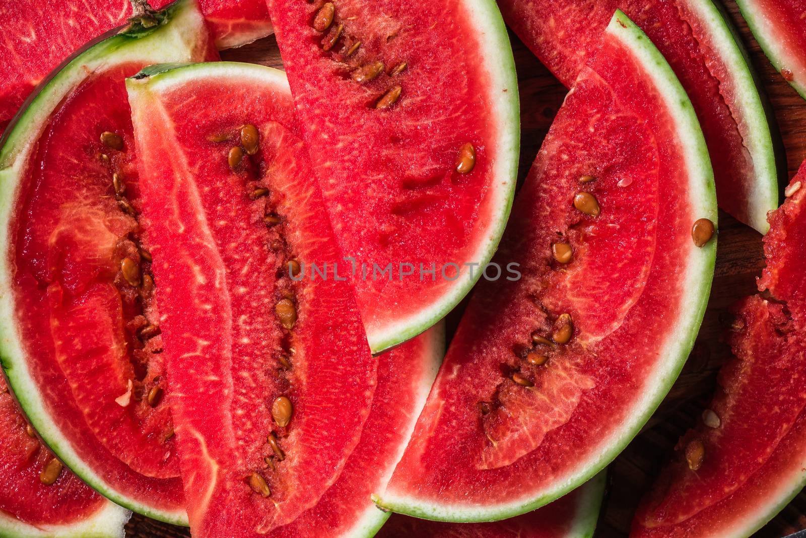 Watermelon slices lying on wooden surface. Background