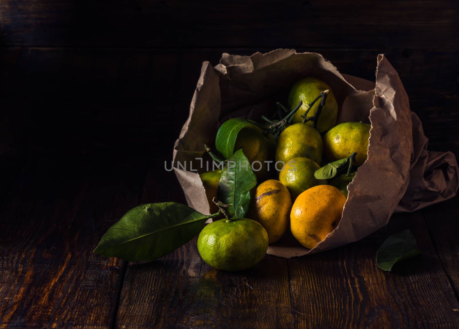 Yellow and Green Tangerines with Leaves in Paper Bundle