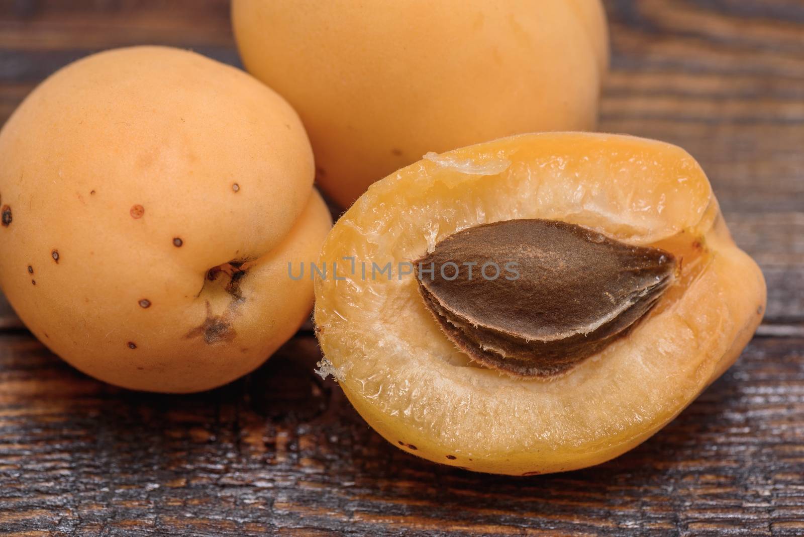 half of apricot on dark wooden table by Seva_blsv