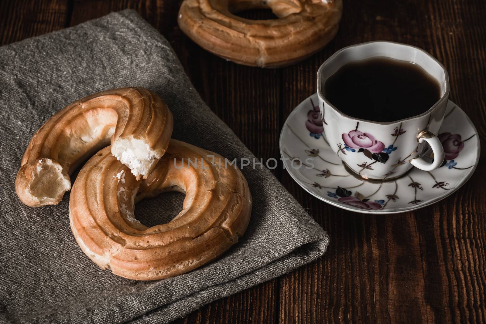 Round eclairs with cup of coffee by Seva_blsv