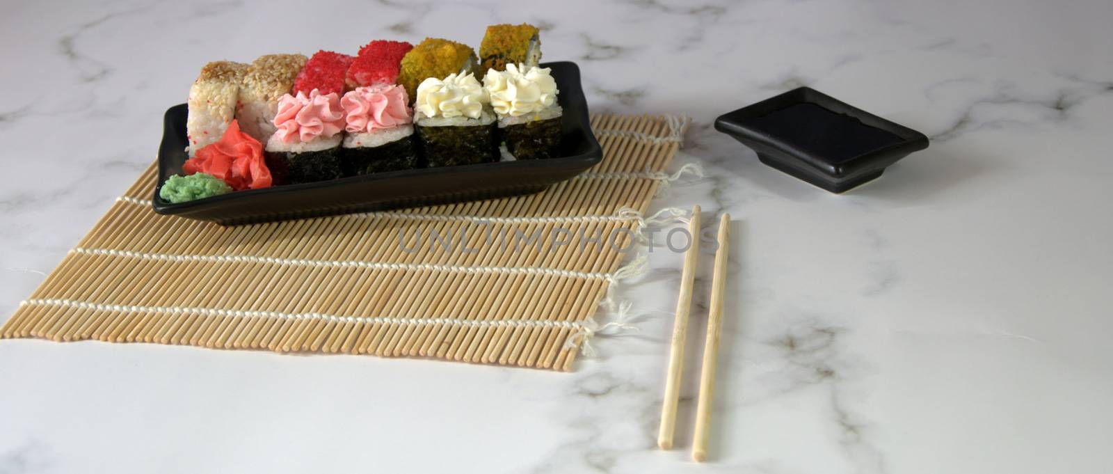 Sushi set with soy sauce, wasabi and ginger on a bamboo napkin. Close-up.