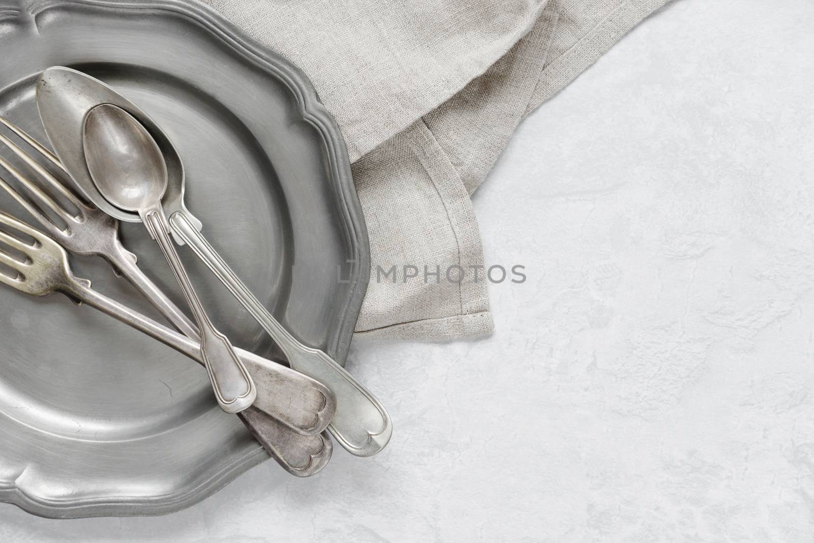 Silverware on a pewter plate by Epitavi