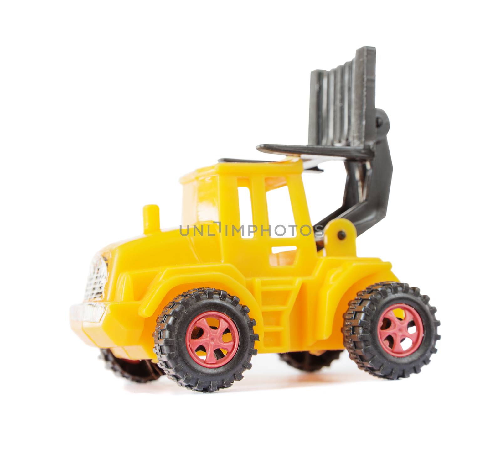 Yellow toy forklift made of plastic, with a raised loader, isolated on a white background, side view
