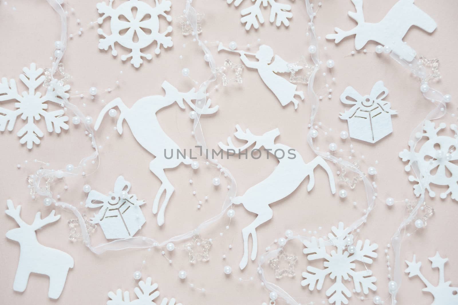 Christmas background composed of white christmas decoration: snowflakes, deers, flying angel and gift boxes on pink background. Christmas wallpaper. Flat lay composition for websites, social media, business owners, magazines,  bloggers, artists etc.