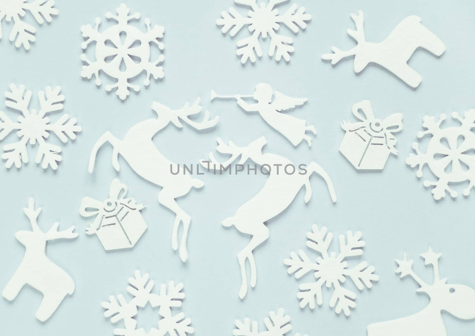 Christmas background composed of white christmas decoration: snowflakes, deers, flying angel and gift boxes on blue background. Christmas wallpaper. Flat lay composition for websites, social media, business owners, magazines,  bloggers, artists etc.