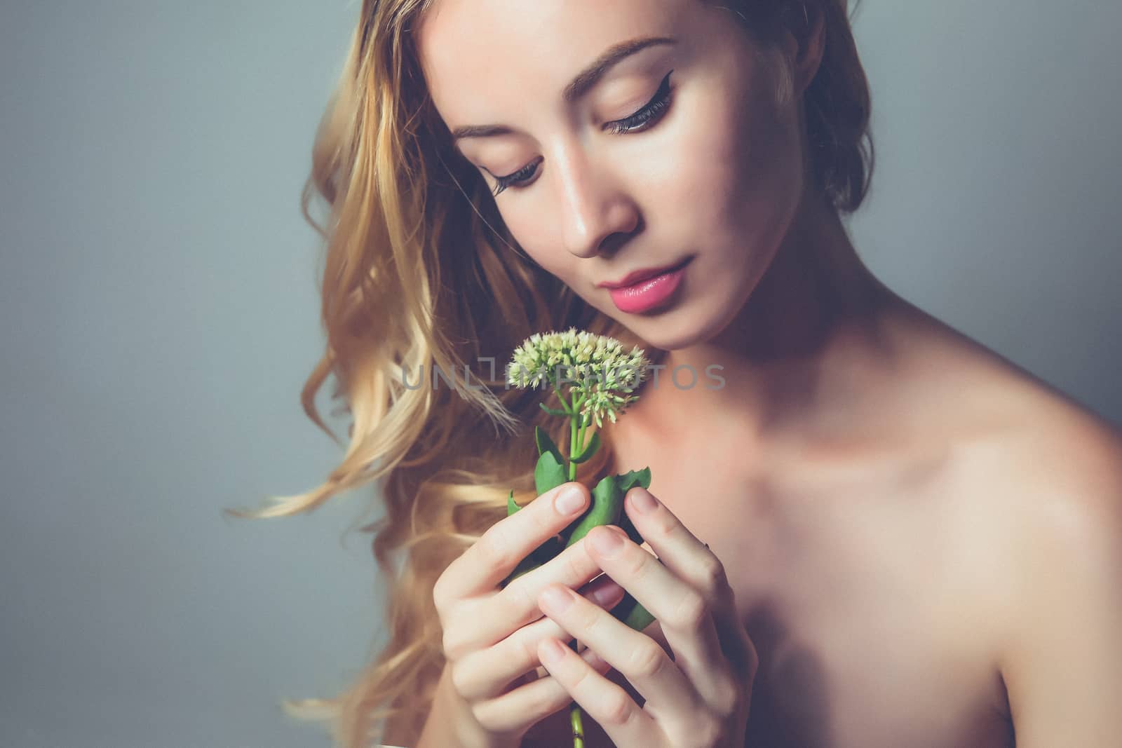 young attractive woman holding flower of calanchoe in hands