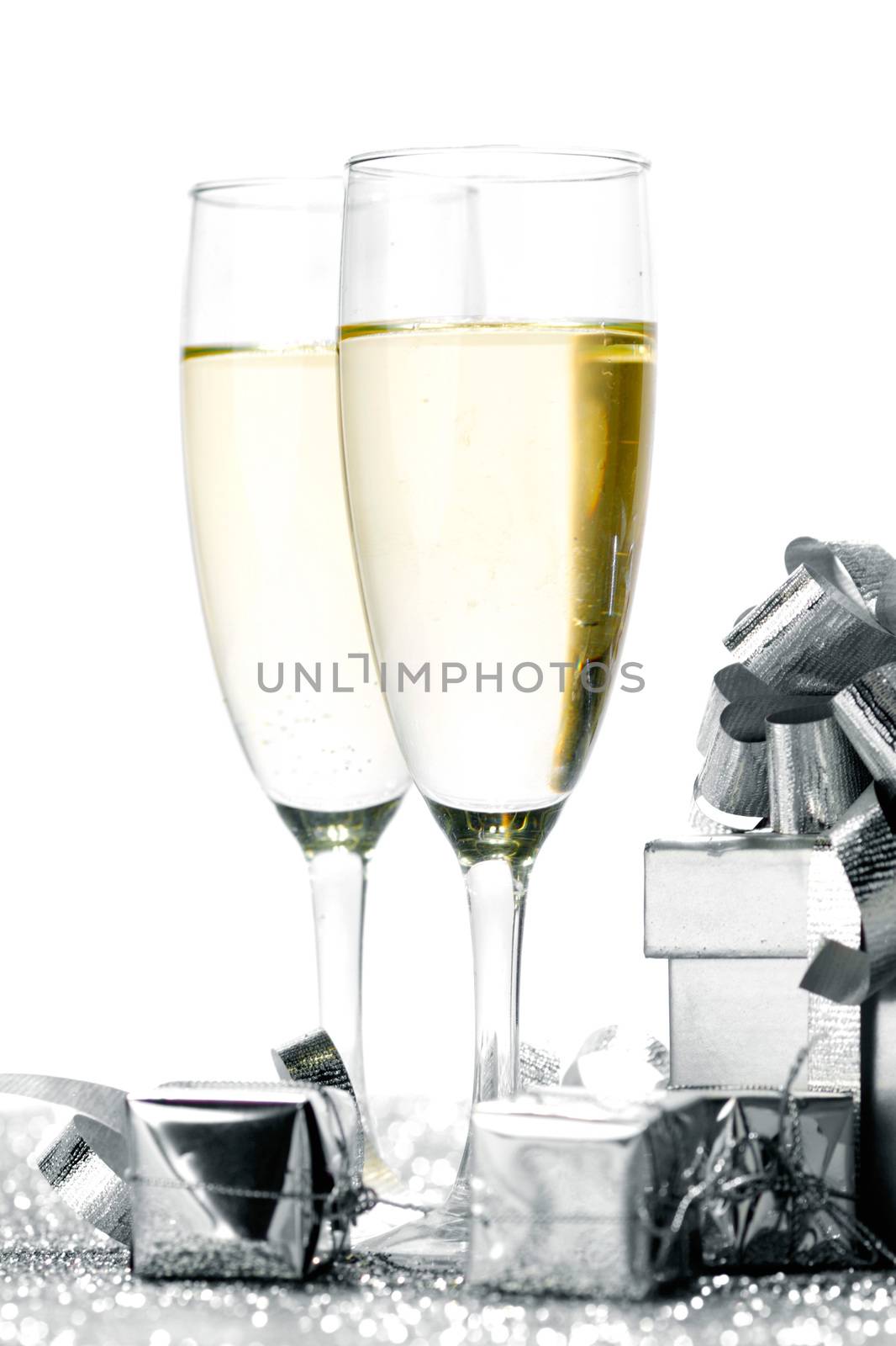 Glasses of champagne and christmas gifts on silver background