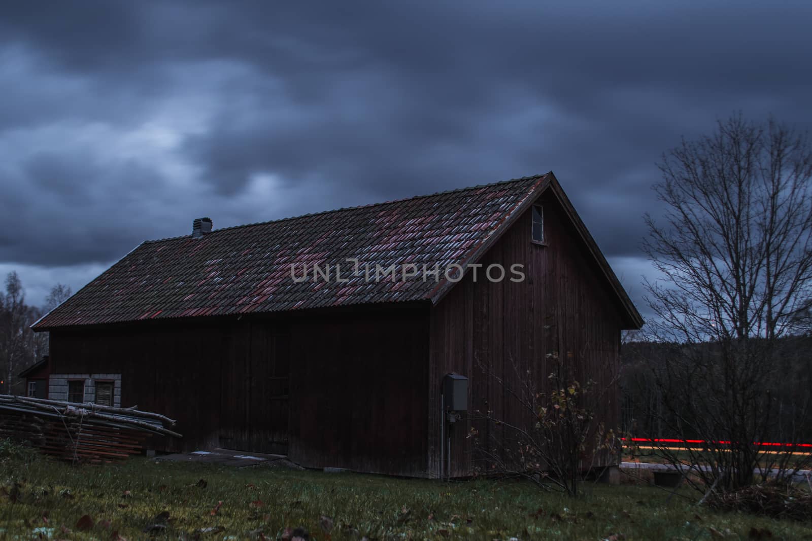 Long exposure of a old barn by a road with car trails