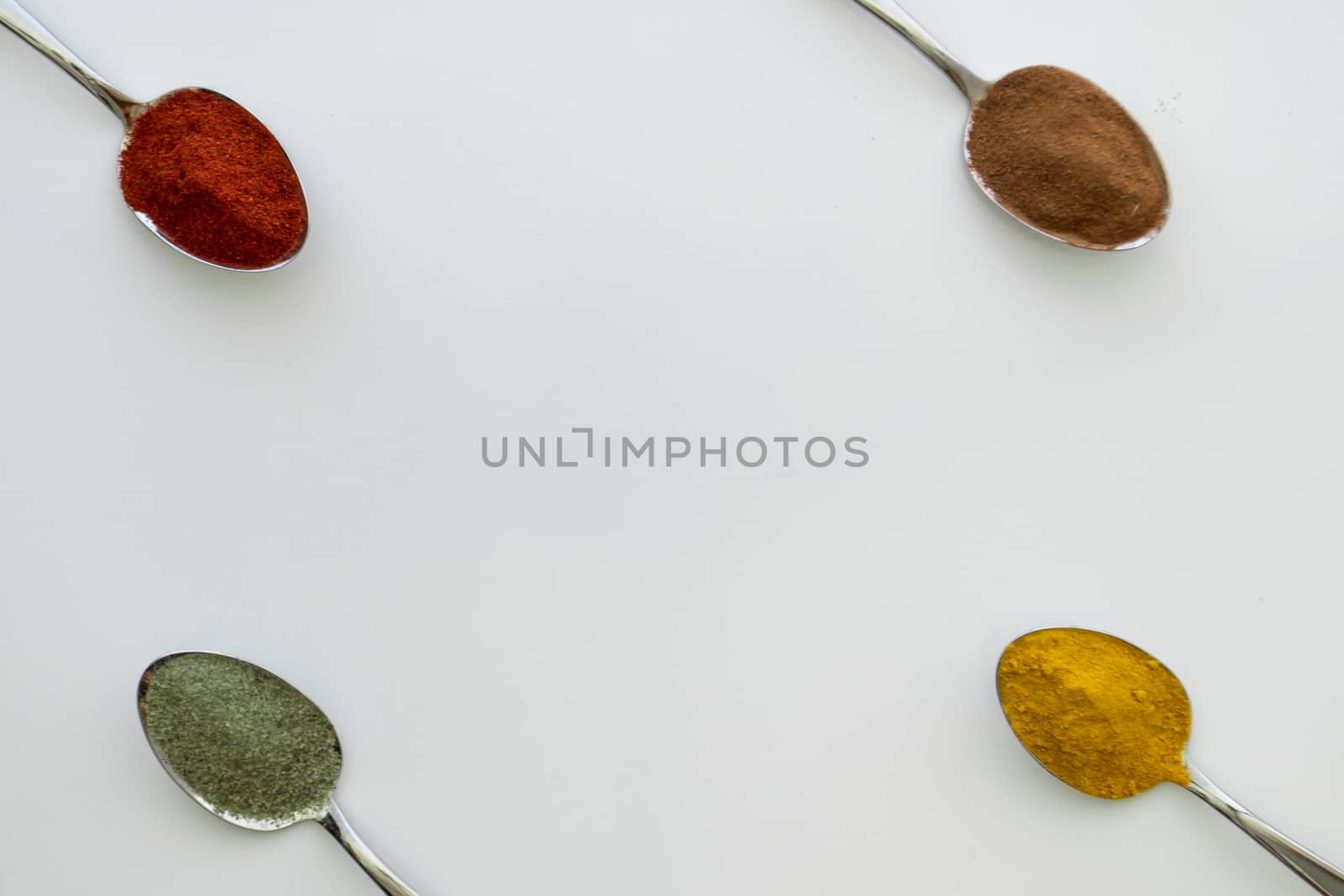 Various colorful spices arranged on spoons  by arvidnorberg