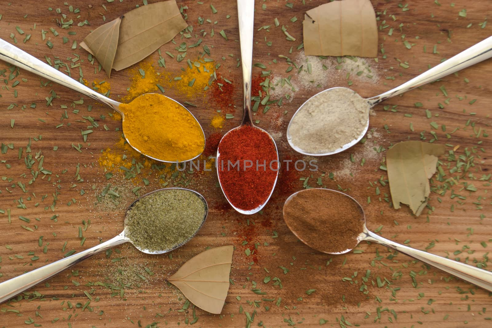 Various colorful spices arranged on spoons  by arvidnorberg