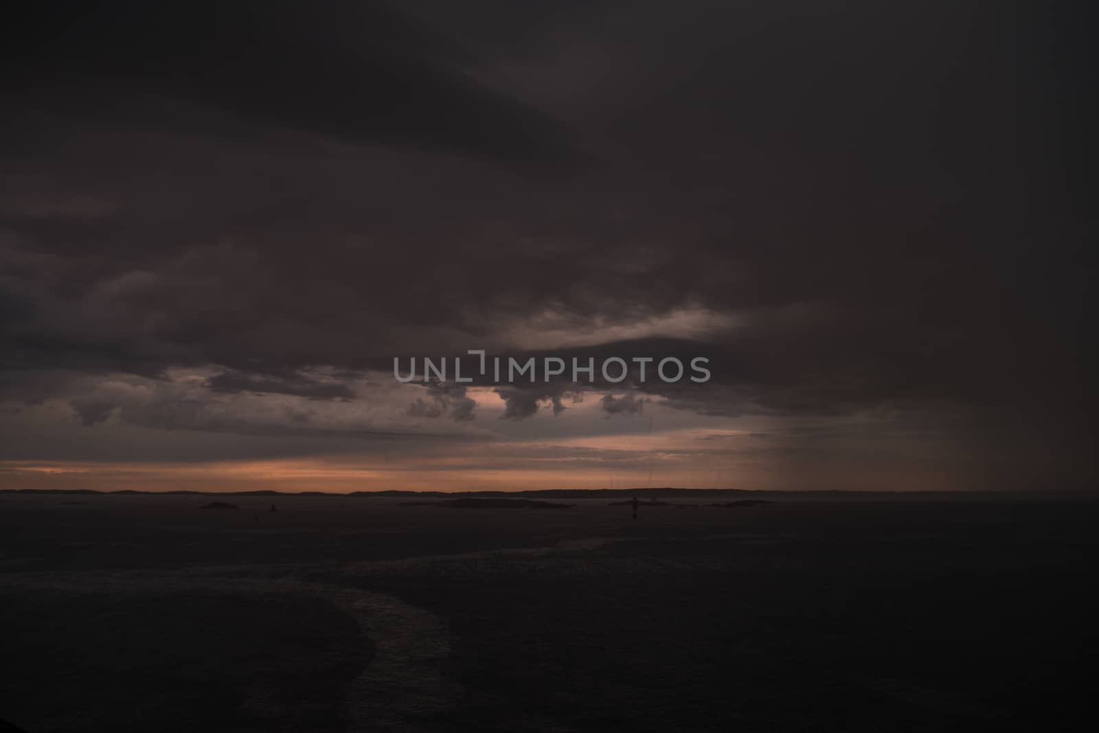 Stormy powerful clouds by the ocean during sunset